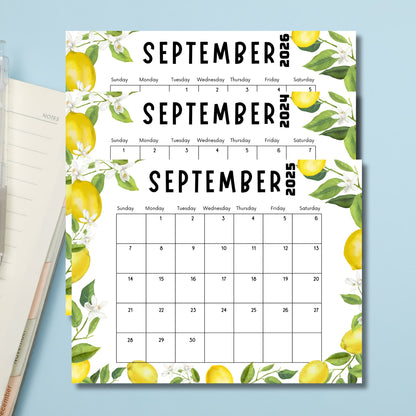 September calendars with lemon design next to notebook and pencil. Light blue background emphasizes fresh, clean aesthetic."