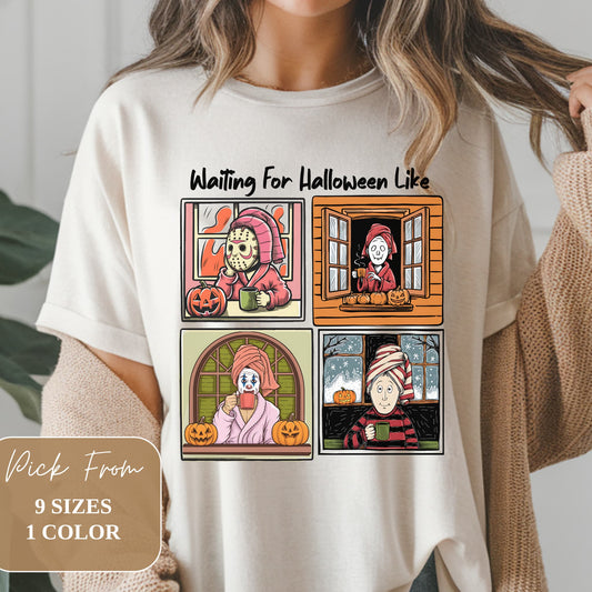 White t-shirt featuring four comic-style panels of horror characters 'Waiting For Halloween'. Includes masked killer, skeleton, clown, and mummy, all with pumpkins and hot drinks. Text overlay indicates 9 sizes available in 1 color. Worn on model with cardigan visible.