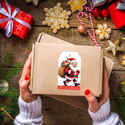 Hands holding kraft gift box decorated with jolly Santa gift tag, surrounded by gingerbread snowflake cookies, candy canes, and Christmas ornaments on rustic wood