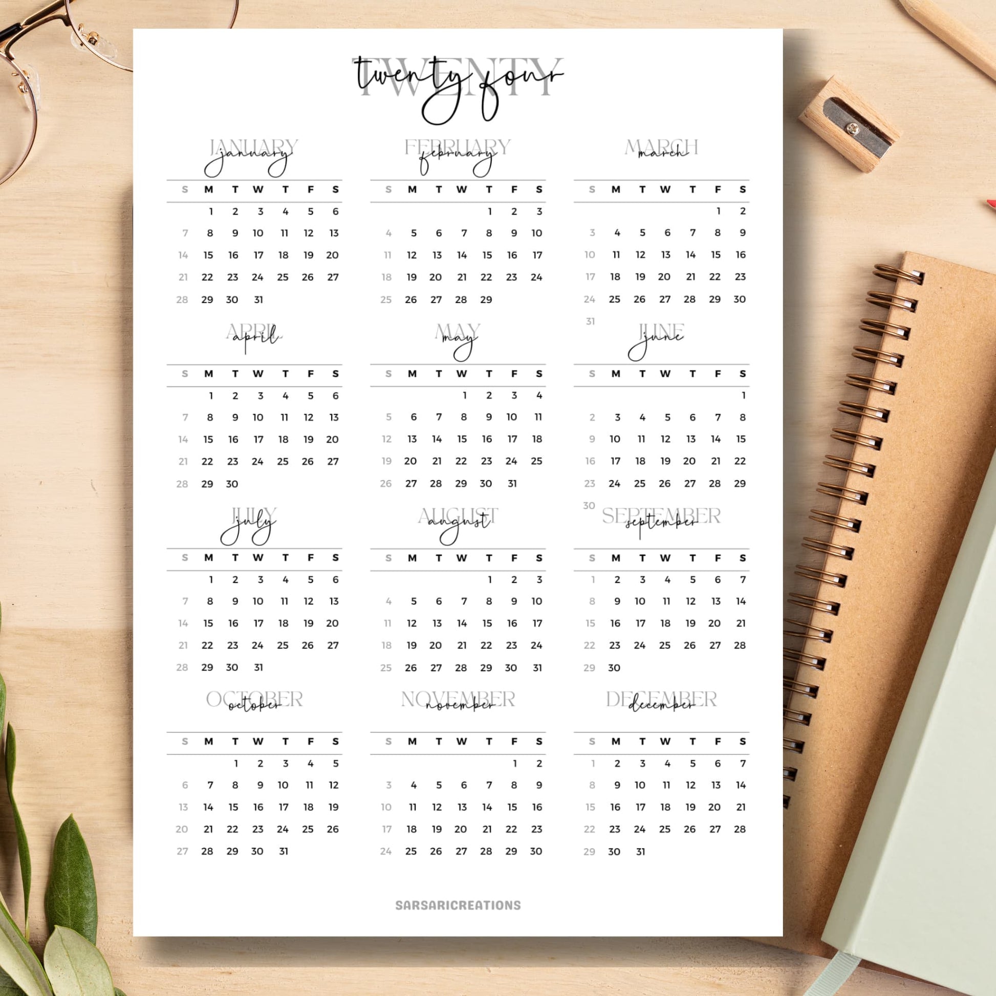 Script font style 2024 calendar page on light brown wooden desk with school supplies like notebook, pencil, sharpener.