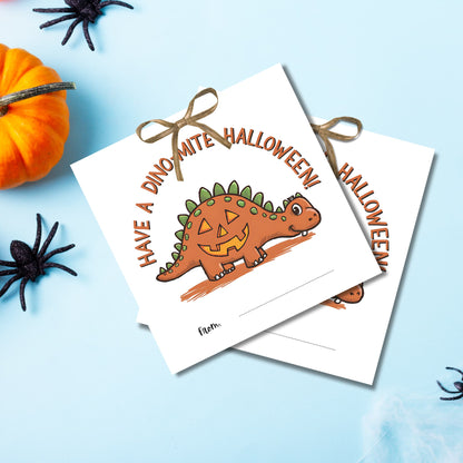 Dino-mite Halloween favor tags featuring a smiling stegosaurus with jack-o'-lantern design, arranged on light blue background with spooky decor